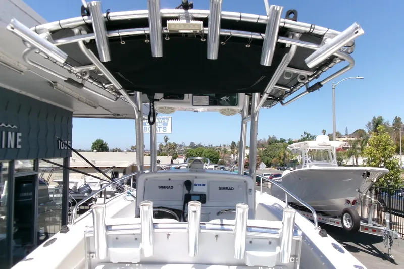 Slide: The Image of 2008 Triumph 235 CC boat with T-top and rod holders, parked outdoors. - 15