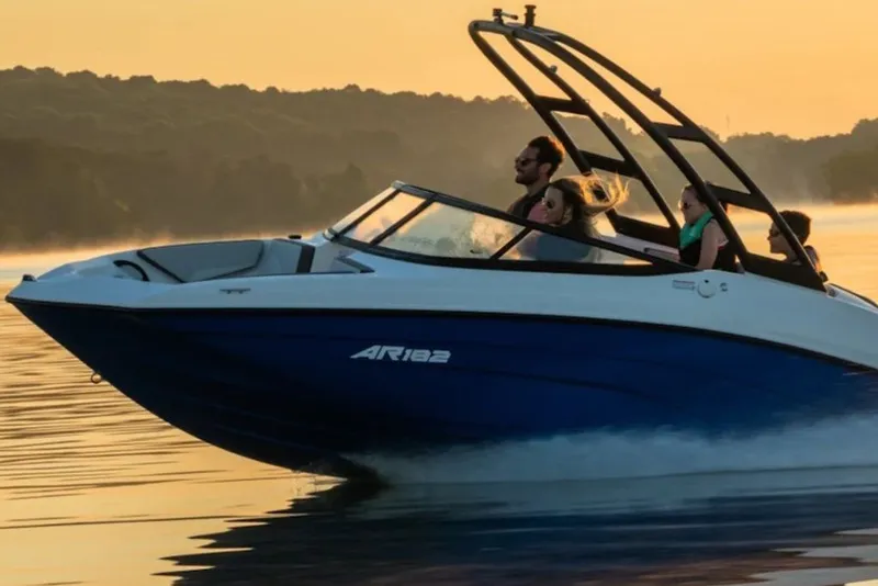 Slide: The Image of 2027 Yamaha Boats AR182 cruising on a serene lake at sunset. - 1