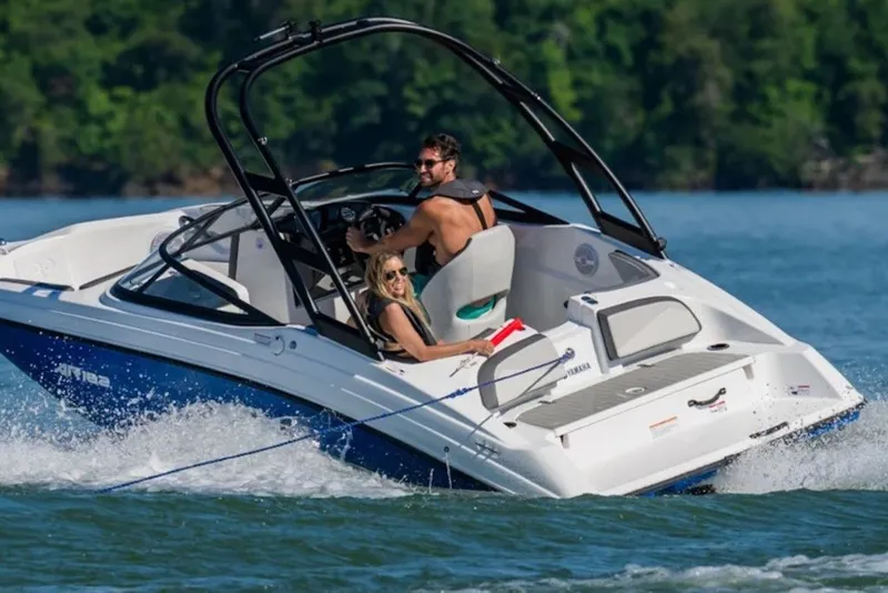 Slide: The Image of 2027 Yamaha Boats AR182 cruising on a lake with two passengers enjoying the ride. - 2