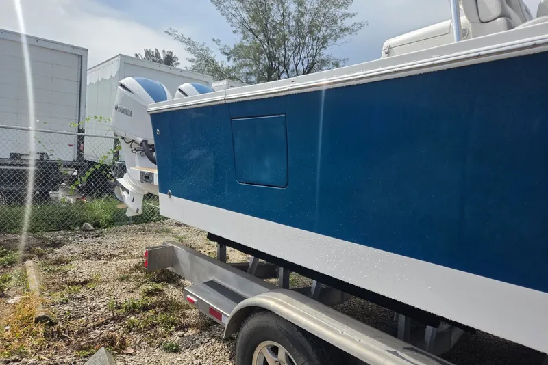 Slide: The Image of 2018 Regulator 34 Center Console boat on trailer, featuring Yamaha engines. - 55