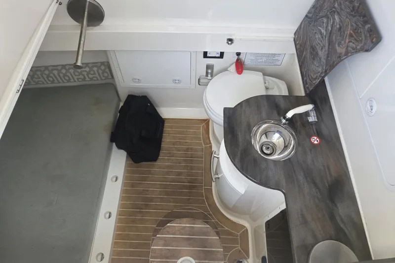 Slide: The Image of 2018 Regulator 34 Center Console interior with sink, toilet, and wooden flooring. - 24