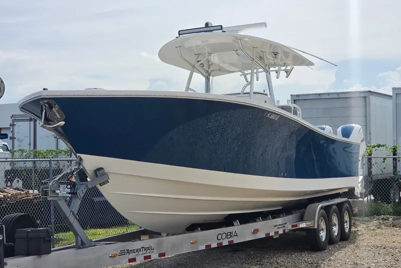 Slide: The Image of 2018 Regulator 34 Center Console boat on trailer, blue hull, parked outdoors. - 43