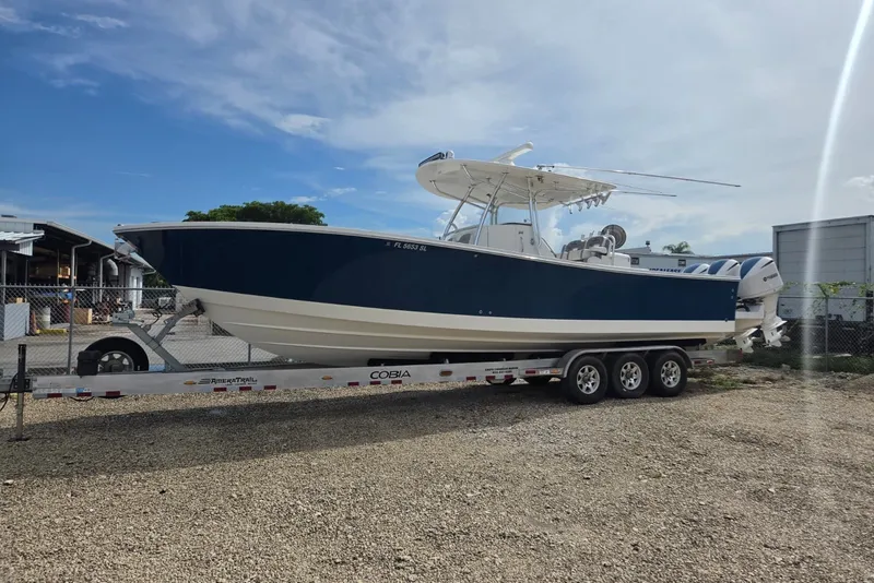 The Image of 2018 Regulator 34 Center Console boat on trailer, parked outdoors under blue sky. - 0
