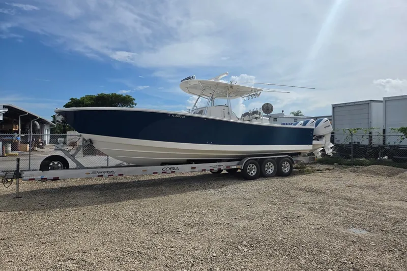 Slide: The Image of 2018 Regulator 34 Center Console boat on trailer, parked outdoors under clear sky. - 63