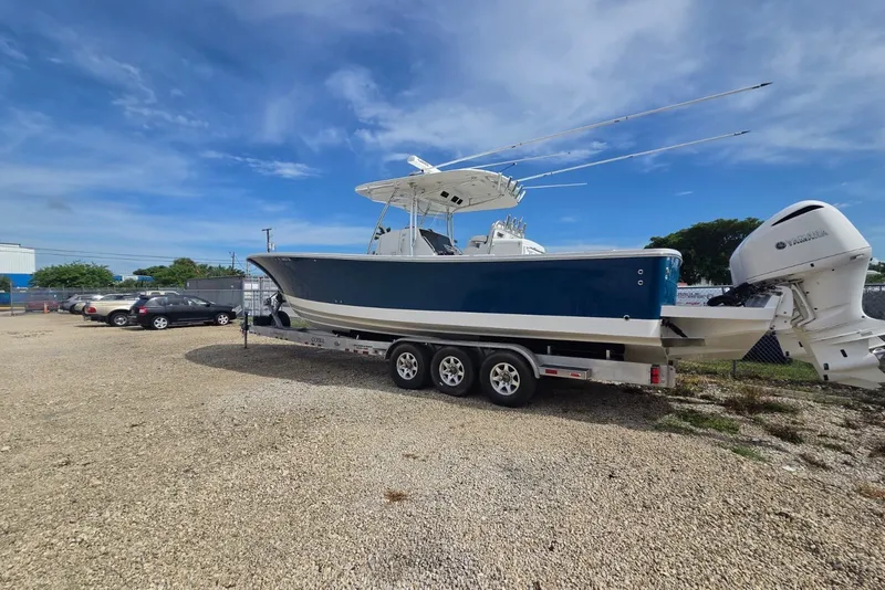 Slide: The Image of 2018 Regulator 34 Center Console boat on trailer, parked outdoors under blue sky. - 47