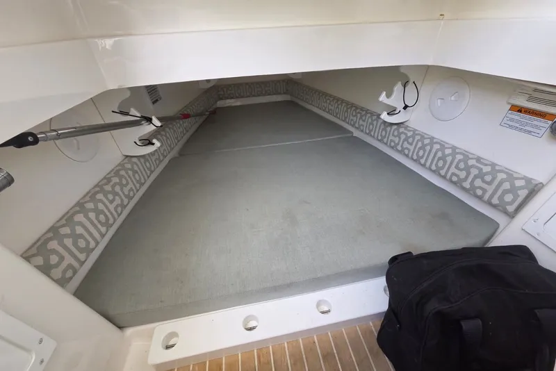 Slide: The Image of 2018 Regulator 34 Center Console cabin interior with cushioned seating and storage. - 19