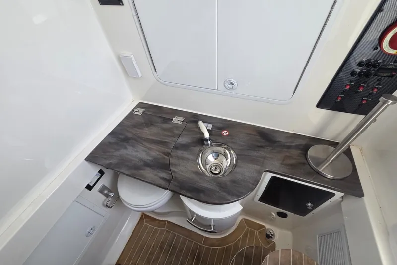 Slide: The Image of 2018 Regulator 34 Center Console boat interior with sink, toilet, and control panel. - 26