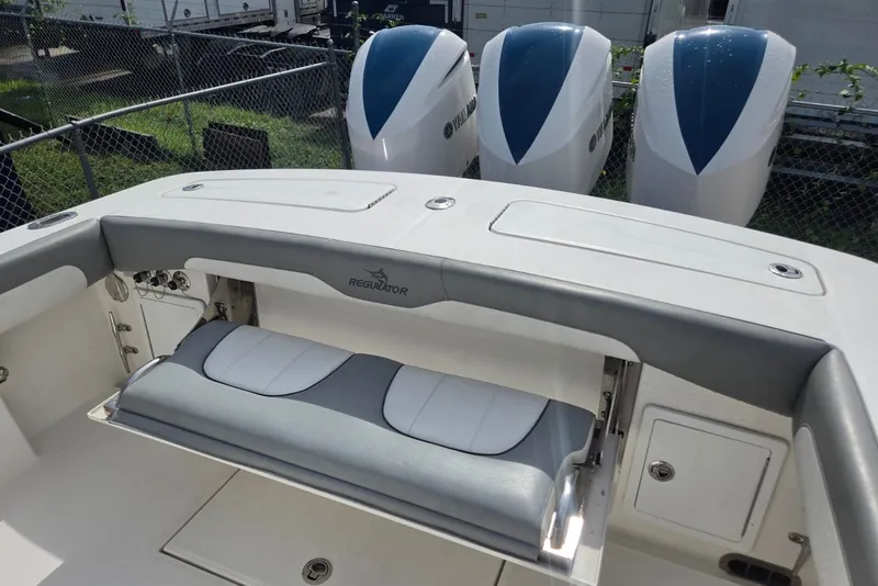 Slide: The Image of 2018 Regulator 34 Center Console boat with triple Yamaha engines and cushioned seating. - 33
