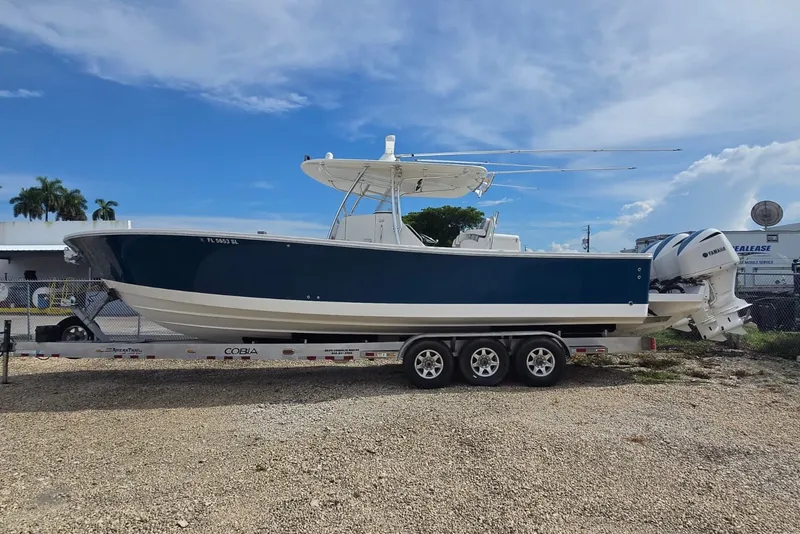 Slide: The Image of 2018 Regulator 34 Center Console boat on trailer, blue hull, clear sky background. - 41