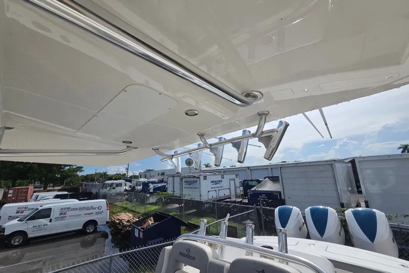 Slide: The Image of 2018 Regulator 34 Center Console boat with rod holders and engines, parked near service vehicles. - 27