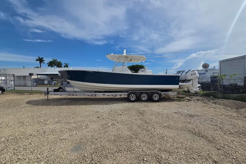 Slide: The Image of 2018 Regulator 34 Center Console boat on trailer, parked outdoors under a clear sky. - 42