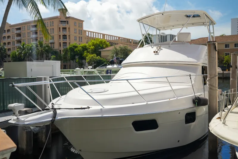 Slide: The Image of 2014 Silverton 36 Convertible yacht docked in a marina, surrounded by palm trees and buildings. - 6