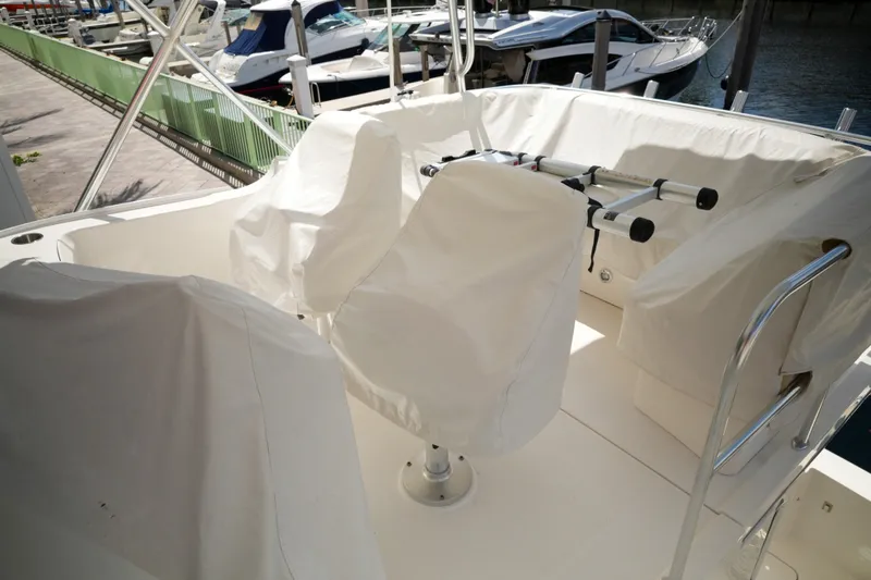 Slide: The Image of 2014 Silverton 36 Convertible boat interior with covered seats at a marina. - 10