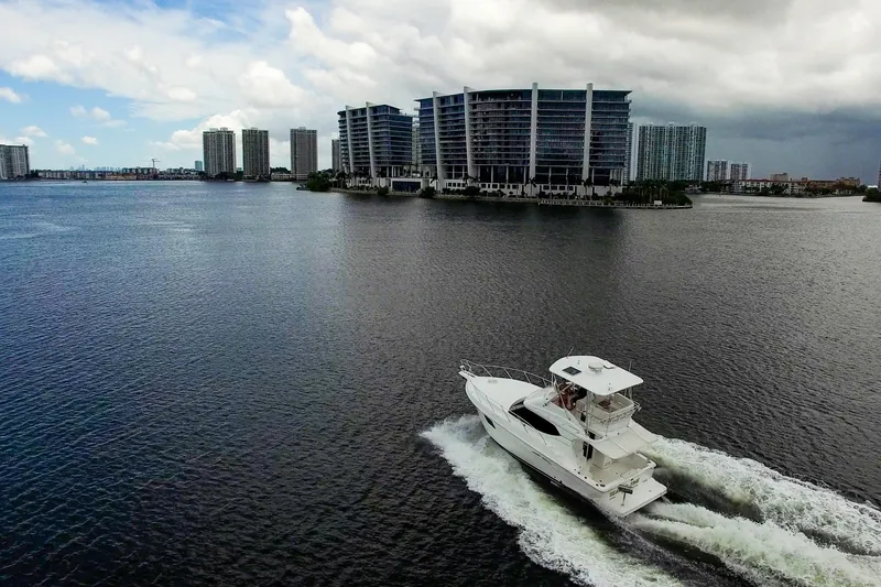 Slide: The Image of 2014 Silverton 36 Convertible yacht cruising near waterfront cityscape. - 36