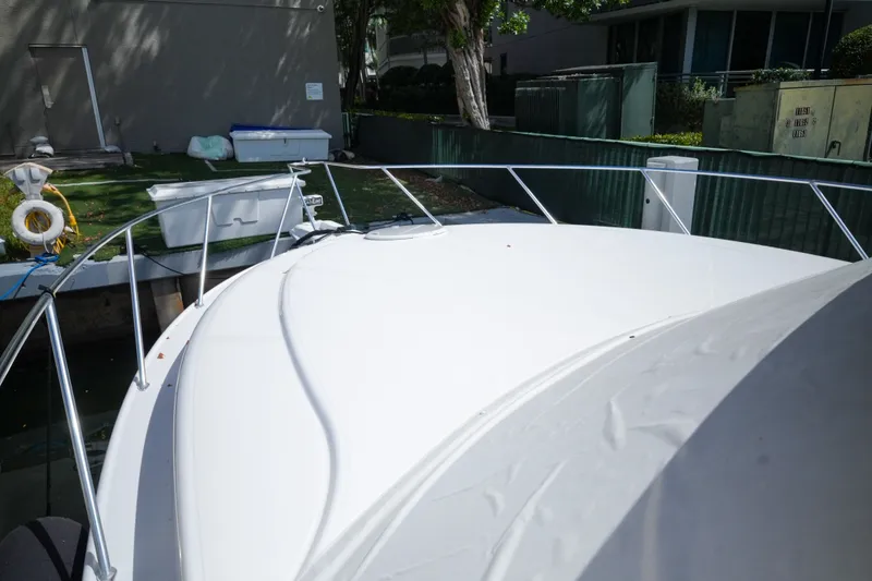 Slide: The Image of 2014 Silverton 36 Convertible yacht docked, showcasing sleek white deck and railing. - 8