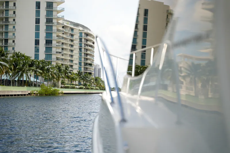 Slide: The Image of 2014 Silverton 36 Convertible yacht cruising near waterfront buildings and palm trees. - 16