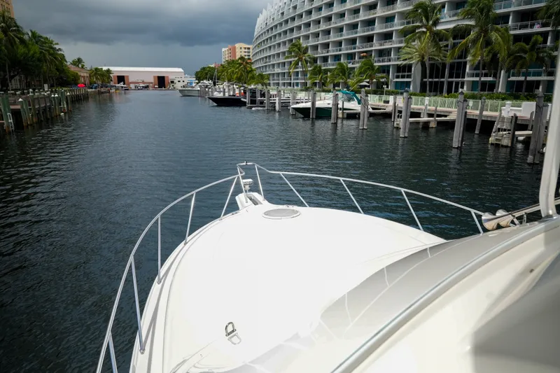 Slide: The Image of Silverton 36 Convertible yacht navigating a marina with modern buildings and palm trees. - 28