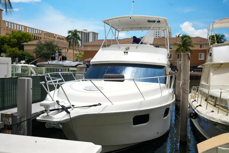 Slide: The Image of 2014 Silverton 36 Convertible yacht docked in a marina under a clear blue sky. - 30