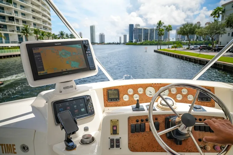 Slide: The Image of Helm of 2014 Silverton 36 Convertible yacht with navigation equipment and cityscape view. - 18