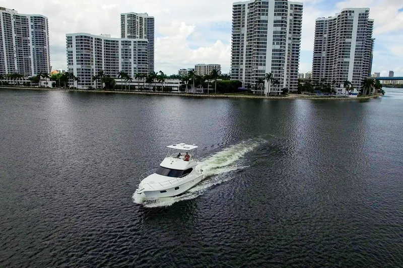 Slide: The Image of 2014 Silverton 36 Convertible yacht cruising near waterfront skyscrapers. - 34