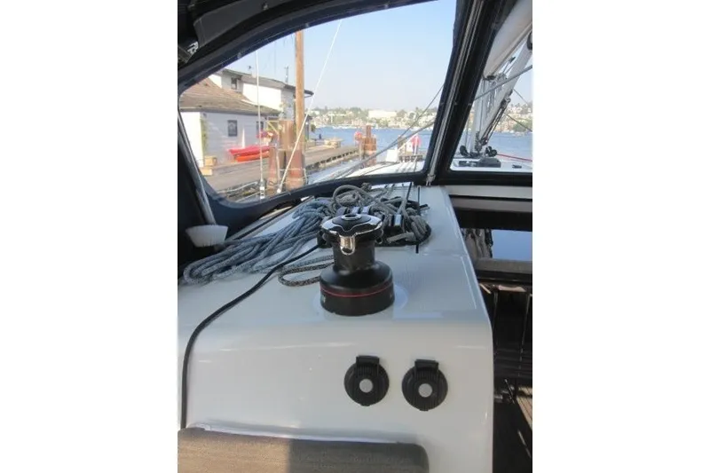 Slide: The Image of 2024 Jeanneau Sun Odyssey 380 sailboat cockpit with winch and ropes, docked by the water. - 50