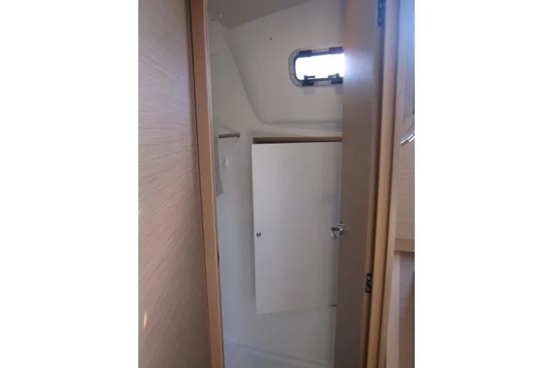 Slide: The Image of Interior view of 2024 Jeanneau Sun Odyssey 380 sailboat bathroom with window and storage. - 13