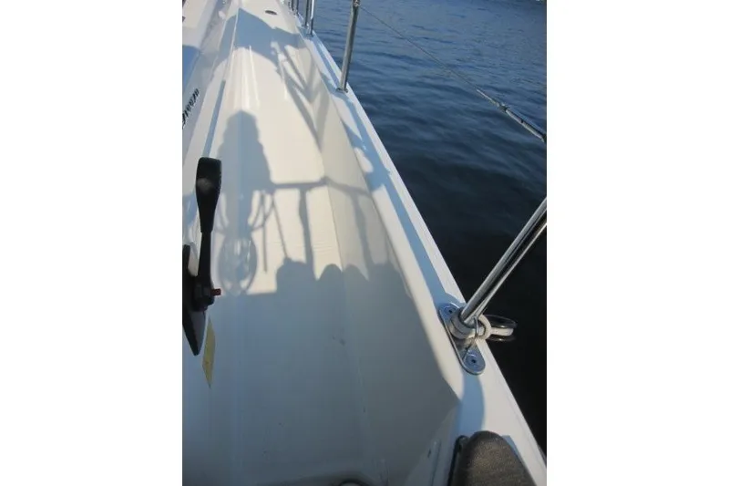 Slide: The Image of 2024 Jeanneau Sun Odyssey 380 deck view with railing and water backdrop. - 49