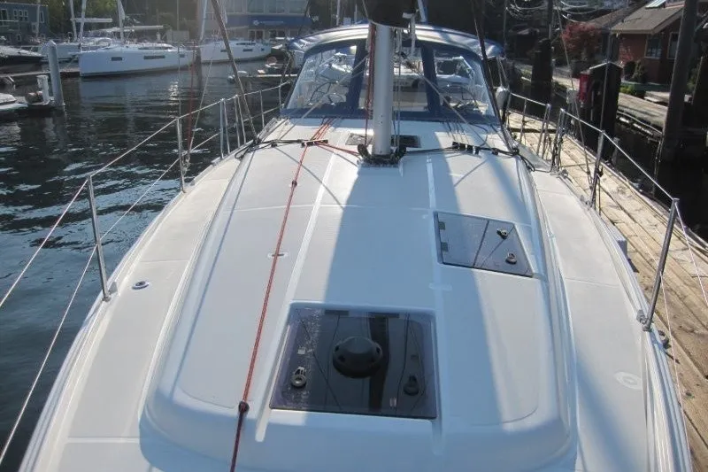 Slide: The Image of 2024 Jeanneau Sun Odyssey 380 sailboat docked at a marina, showcasing its sleek deck design. - 33