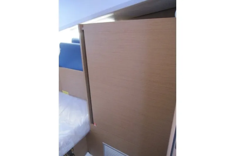 Slide: The Image of Interior view of 2024 Jeanneau Sun Odyssey 380 yacht cabin with wooden paneling. - 19
