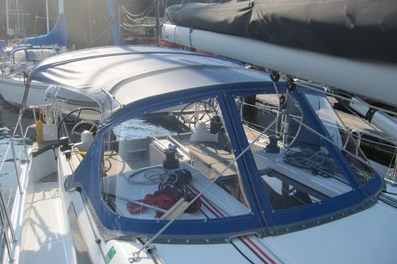 Slide: The Image of 2024 Jeanneau Sun Odyssey 380 sailboat with blue canopy docked at marina. - 34