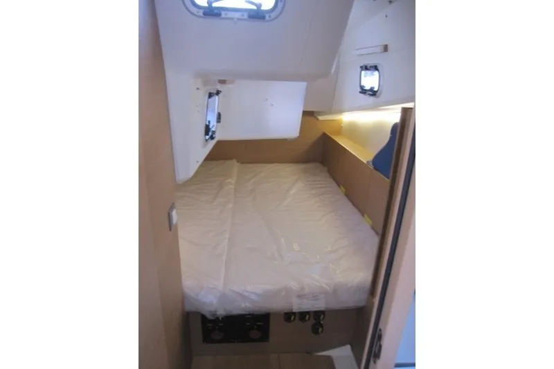 Slide: The Image of Interior cabin of 2024 Jeanneau Sun Odyssey 380 sailboat, featuring a cozy bed. - 17