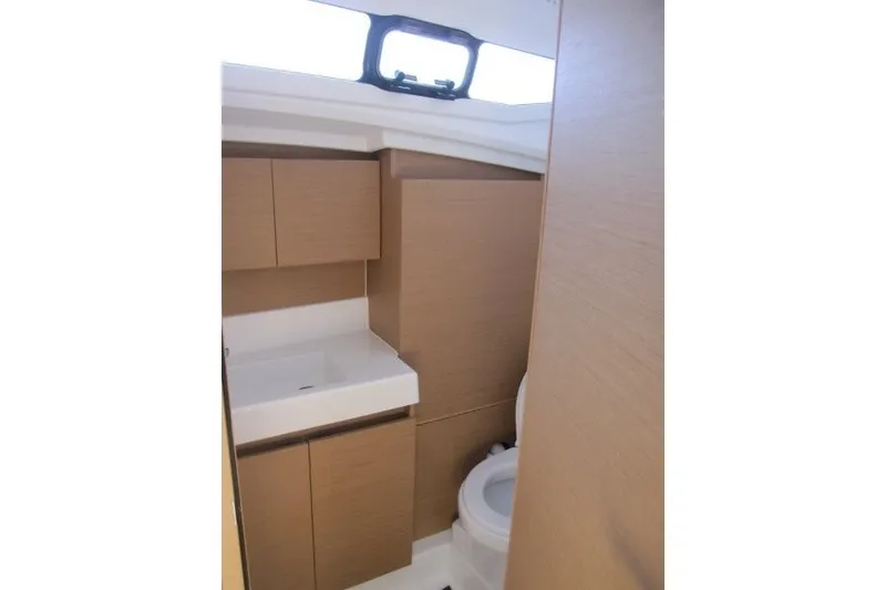 Slide: The Image of 2024 Jeanneau Sun Odyssey 380 bathroom with modern fixtures and wooden cabinetry. - 15