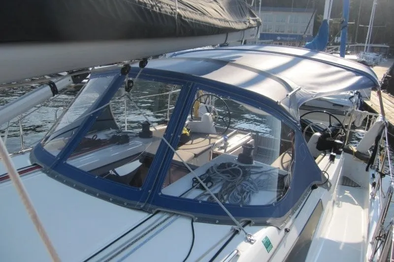 Slide: The Image of 2024 Jeanneau Sun Odyssey 380 sailboat with blue canopy docked at marina. - 35