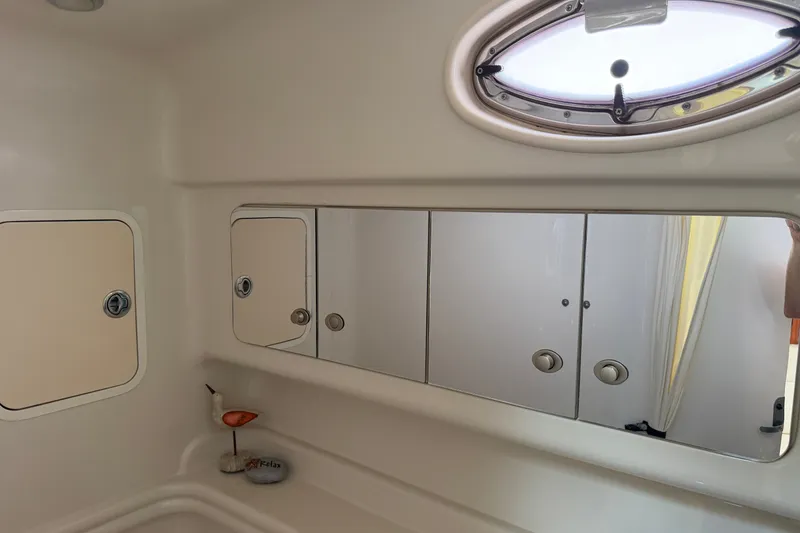 Slide: The Image of 2006 Sea Ray Sundancer 320 bathroom interior with mirrored cabinets and porthole window. - 70
