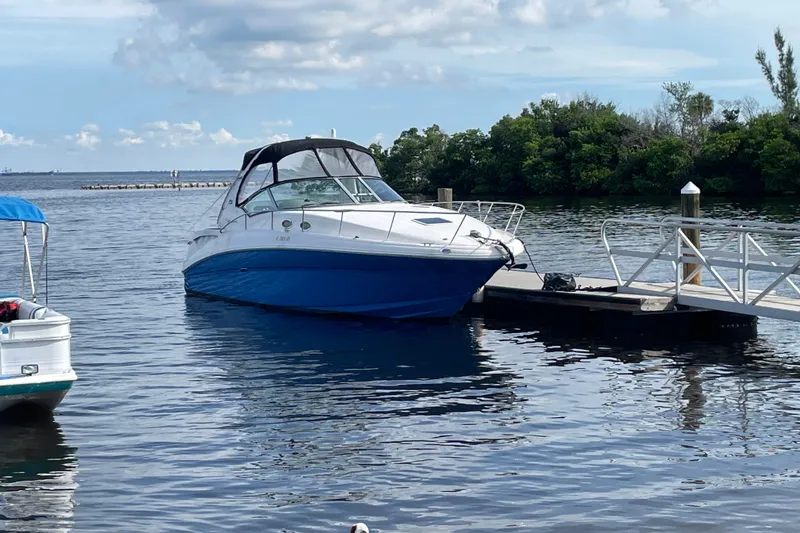 Slide: The Image of 2006 Sea Ray Sundancer 320 docked on a calm lake under a partly cloudy sky. - 0