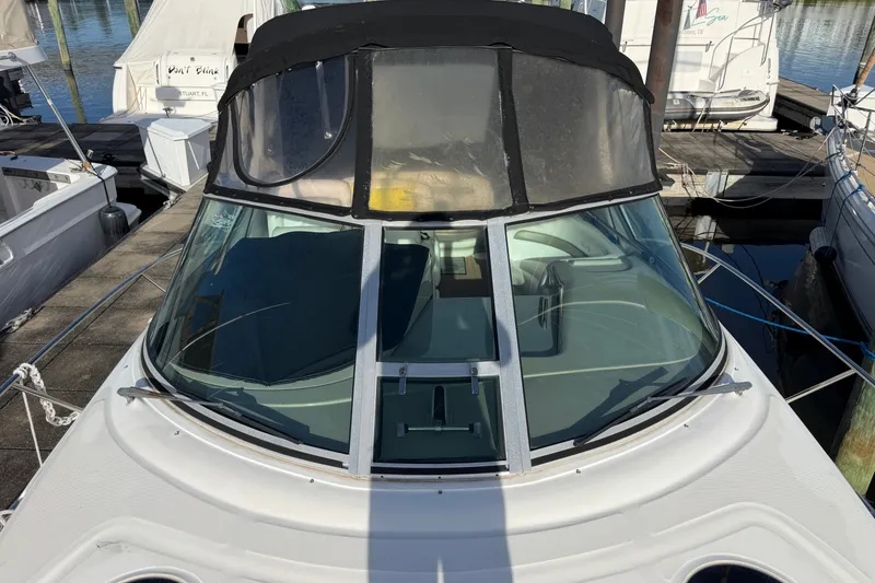 Slide: The Image of 2006 Sea Ray Sundancer 320 docked, featuring sleek design and tinted windshield. - 23