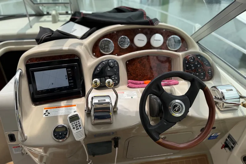 Slide: The Image of 2006 Sea Ray Sundancer 320 helm with steering wheel, controls, and navigation display. - 6