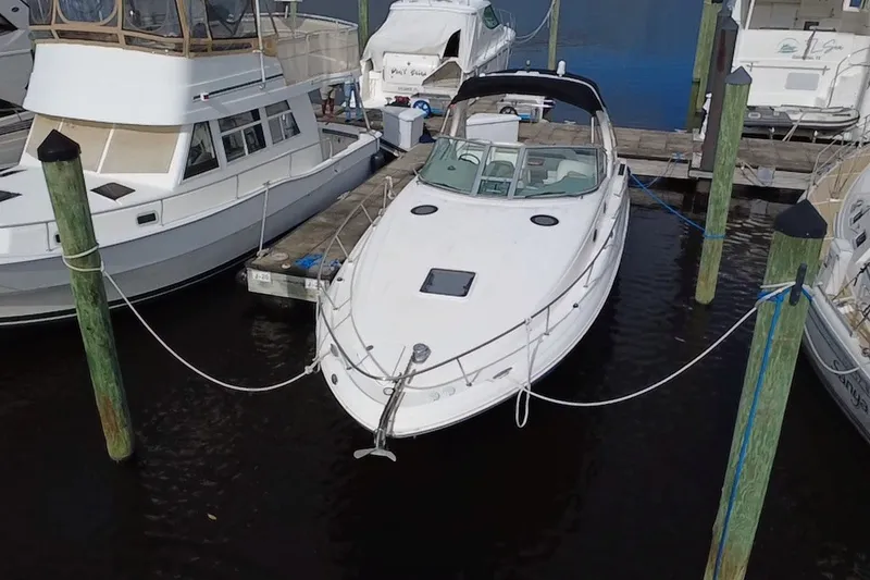 The Image of 2006 Sea Ray Sundancer 320 docked at marina, surrounded by other boats. - 6