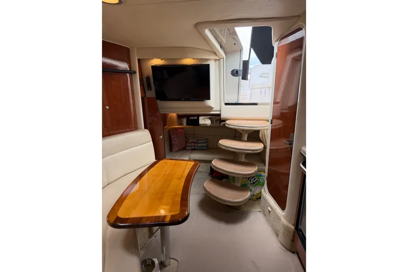 Slide: The Image of Interior of 2006 Sea Ray Sundancer 320 yacht with wooden table and curved stairs. - 16