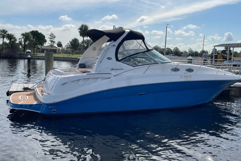 Slide: The Image of 2006 Sea Ray Sundancer 320 yacht docked on calm water under a clear sky. - 2
