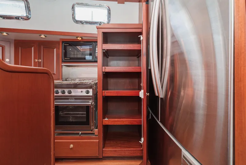 Slide: The Image of Philbrook's 69' Custom PH Sailing Sloop 1999 kitchen with stainless steel appliances and wooden cabinetry. - 42