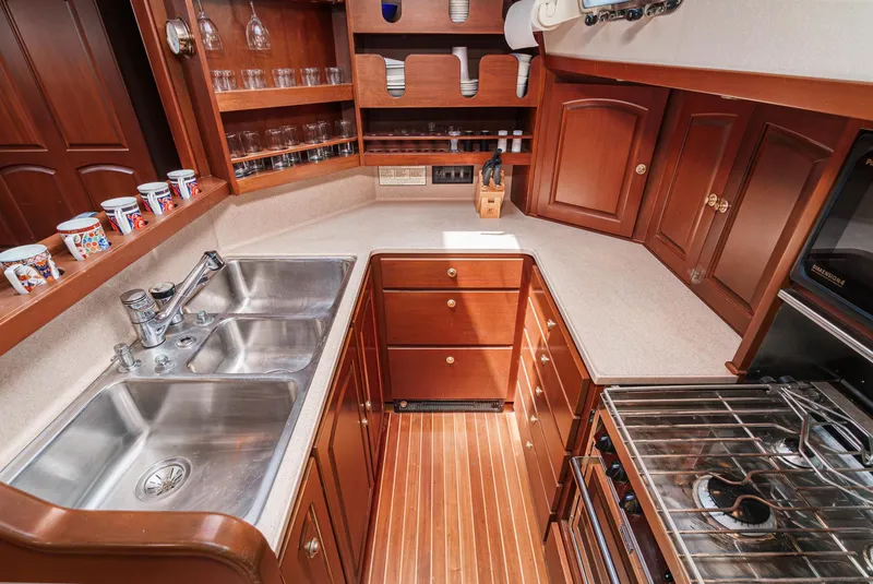 Slide: The Image of Philbrook's 69' Custom PH Sailing Sloop 1999 galley with wood cabinetry and stainless steel sink. - 40