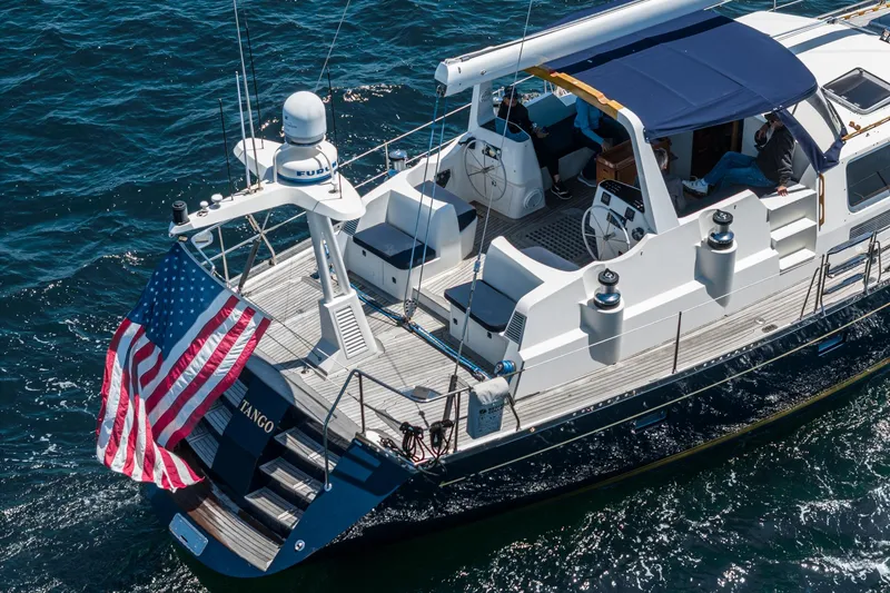 Slide: The Image of Philbrook's 69' Custom PH Sailing Sloop, 1999, with American flag, sailing on open water. - 16