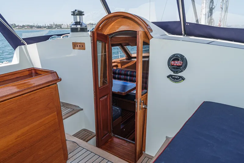 Slide: The Image of Philbrook's 69' Custom PH Sailing Sloop 1999 interior with wooden door and seating area. - 27