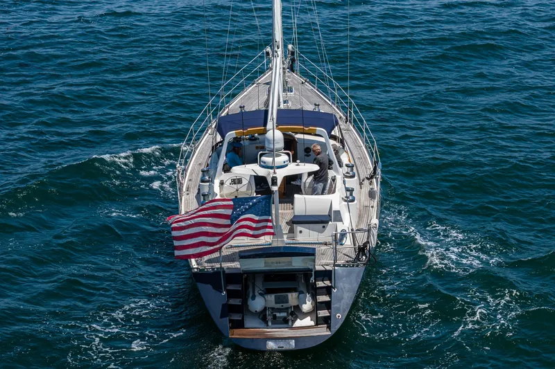 Slide: The Image of Philbrook's 69' Custom PH Sailing Sloop, 1999, sailing on open water with American flag. - 18