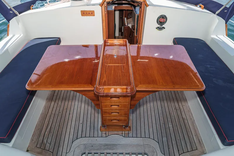 Slide: The Image of Luxurious cockpit of 1999 Philbrook's 69' Custom PH Sailing Sloop with polished wooden table. - 26