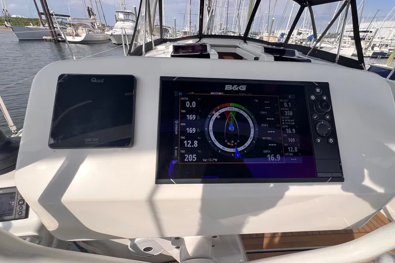 Slide: The Image of Cockpit of 2020 Hanse 458 yacht with navigation display and marina view. - 27
