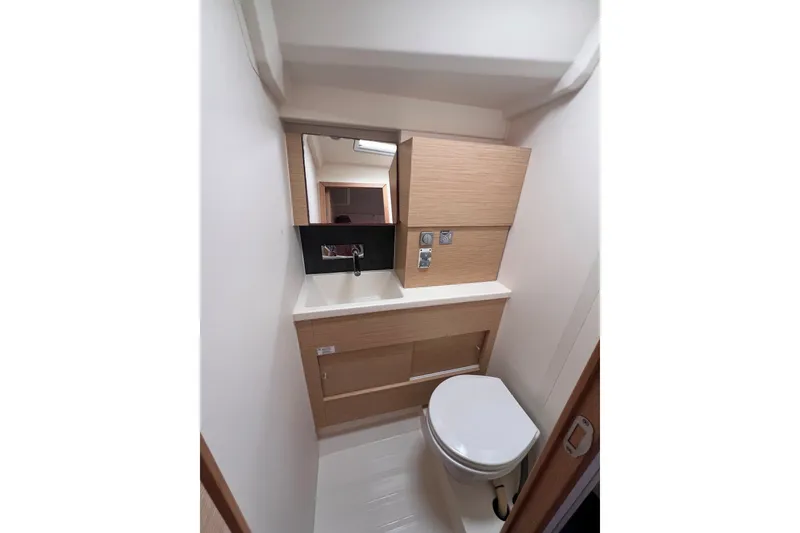 Slide: The Image of Compact bathroom in 2020 Hanse 458 yacht with modern fixtures and wooden cabinetry. - 67