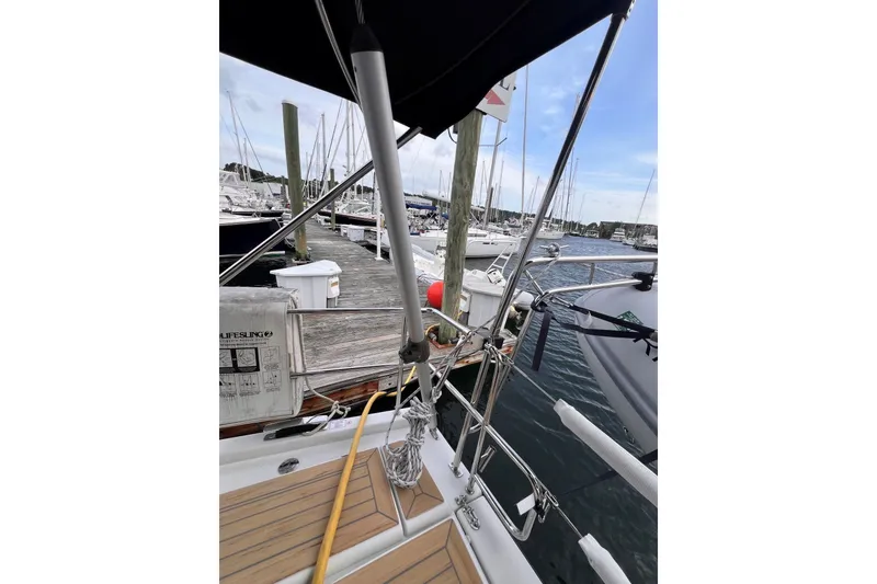 Slide: The Image of 2020 Hanse 458 yacht docked at marina, showcasing deck and railing details. - 34