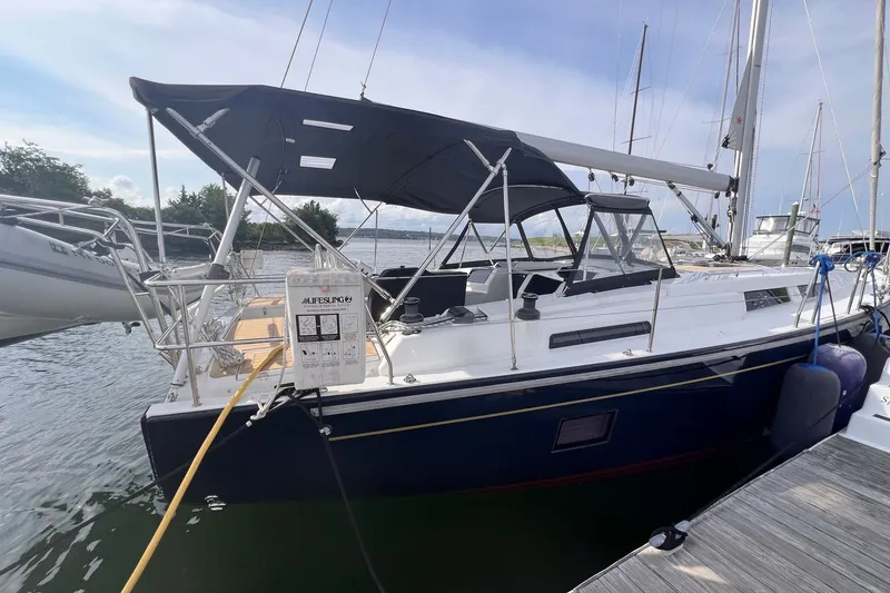 Slide: The Image of 2020 Hanse 458 sailboat docked at marina with black canopy and lifebuoy. - 7